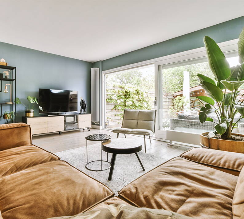 A contemporary living room furnished with high-quality furniture and electronic equipment, representing typical household contents that are insured.